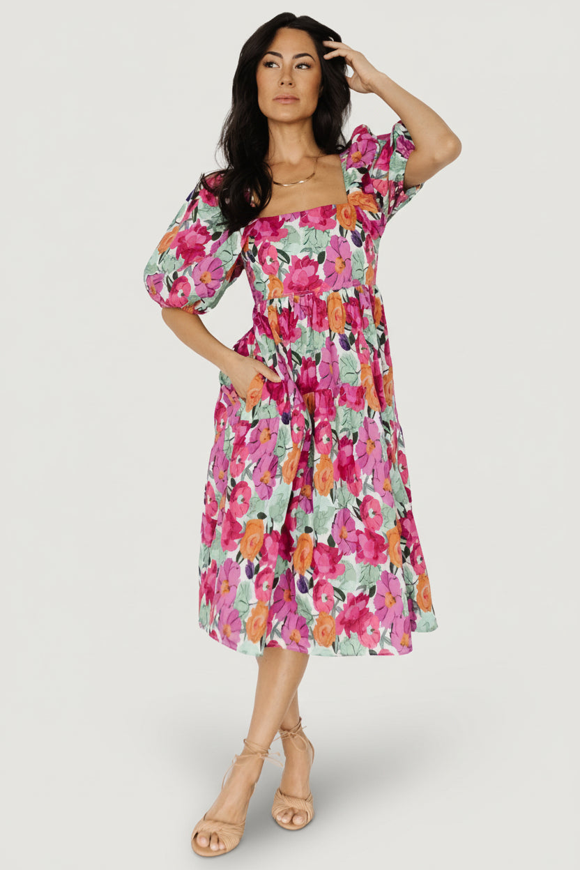 Front view of Aimee puff sleeve midi dress in pink multi floral print showing square neckline, smocked back bodice and gathered waist with side pockets.