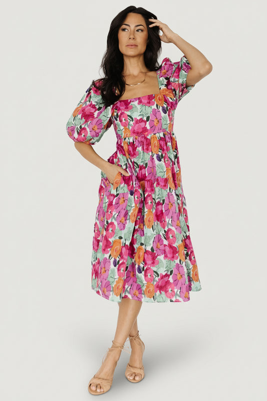 Front view of Aimee puff sleeve midi dress in pink multi floral print showing square neckline, smocked back bodice and gathered waist with side pockets.