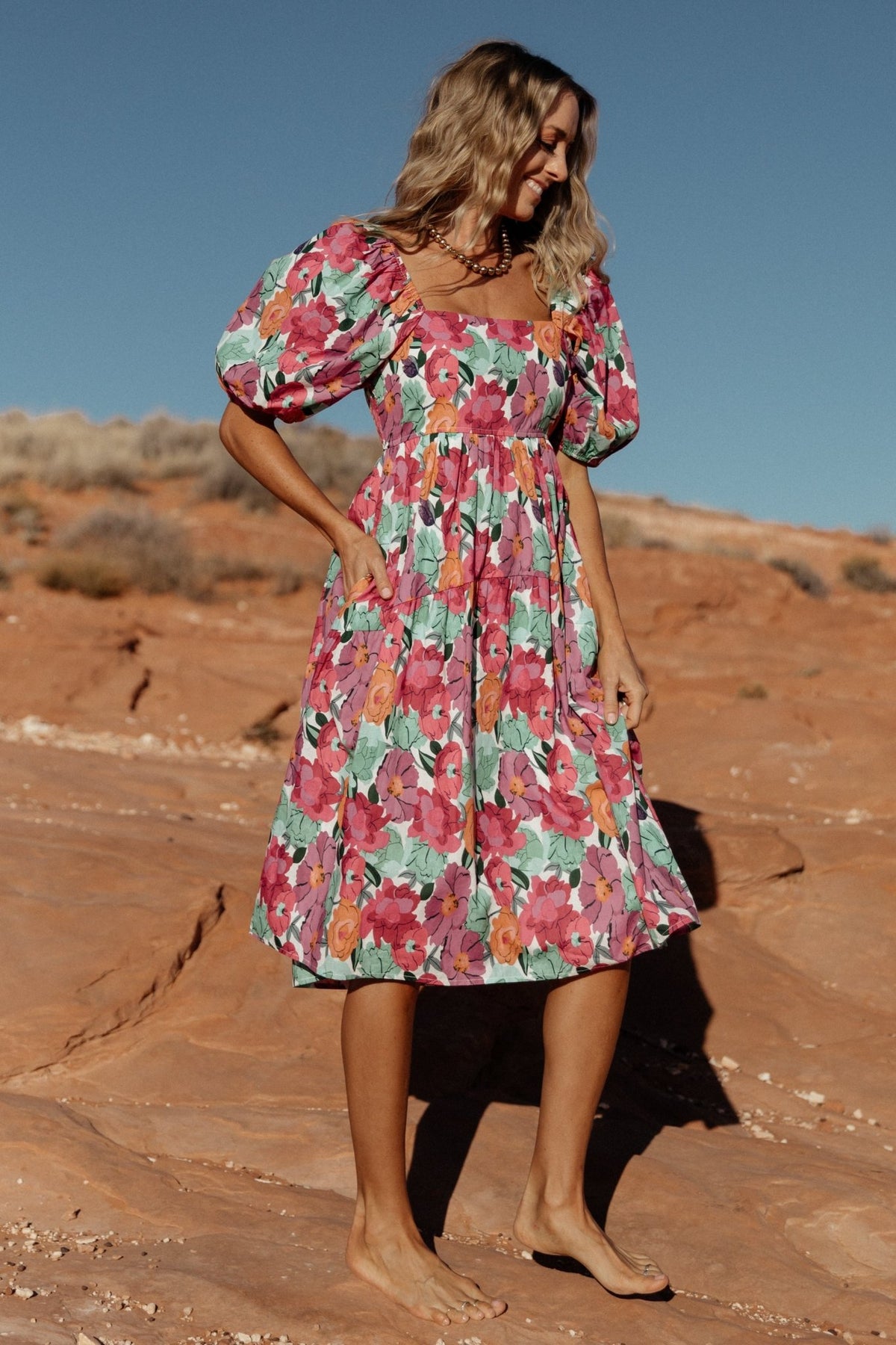 Detail photograph showing oversized puff sleeve and elastic cuff on the Aimee dress in pink multi floral pattern with gather at the shoulder.