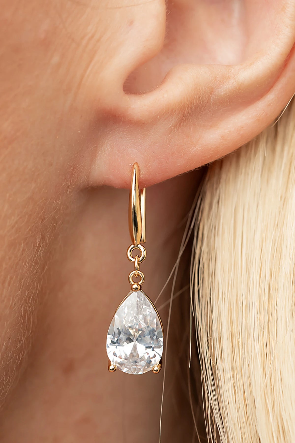 Aira Teardrop Earrings in Gold with clear teardrop stone and sleek hook design.