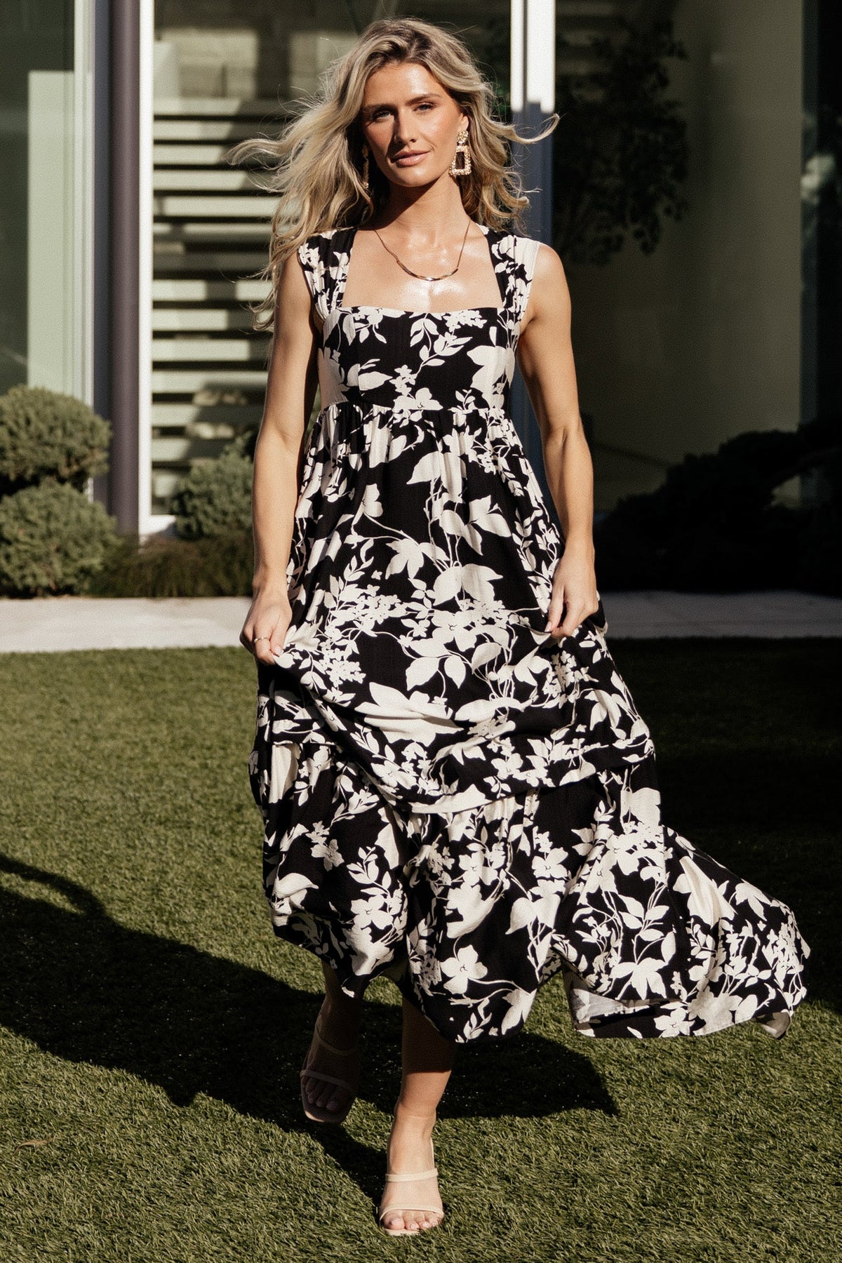 Side profile of the maxi dress illustrating flowing single-tiered skirt, fabric tie at skirt and the placement of the discreet side pockets.