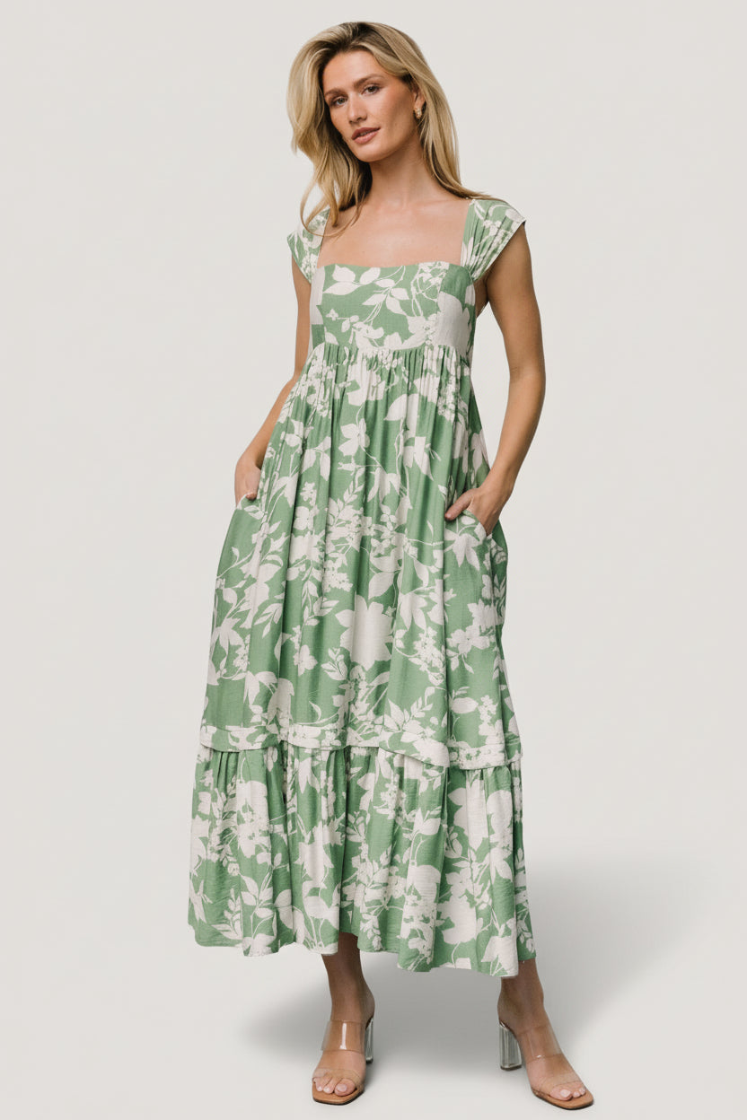 Close-up of smocked back and square neckline on green floral maxi dress highlighting gathered tank cap sleeve detail and fabric texture.