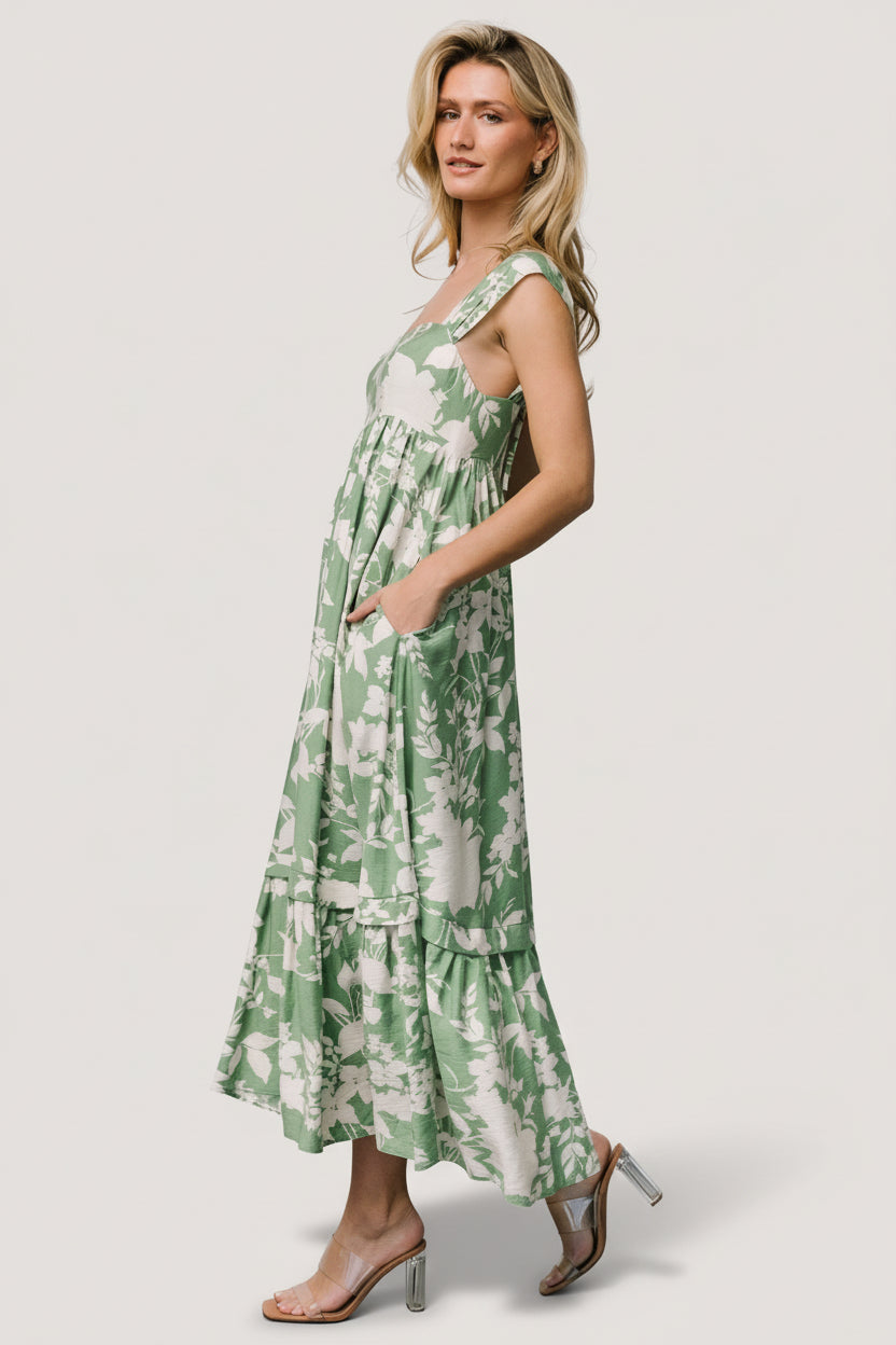 Back view of green and ivory floral maxi dress showing smocked panel, full skirt silhouette, and length hitting at a maxi proportion on model.