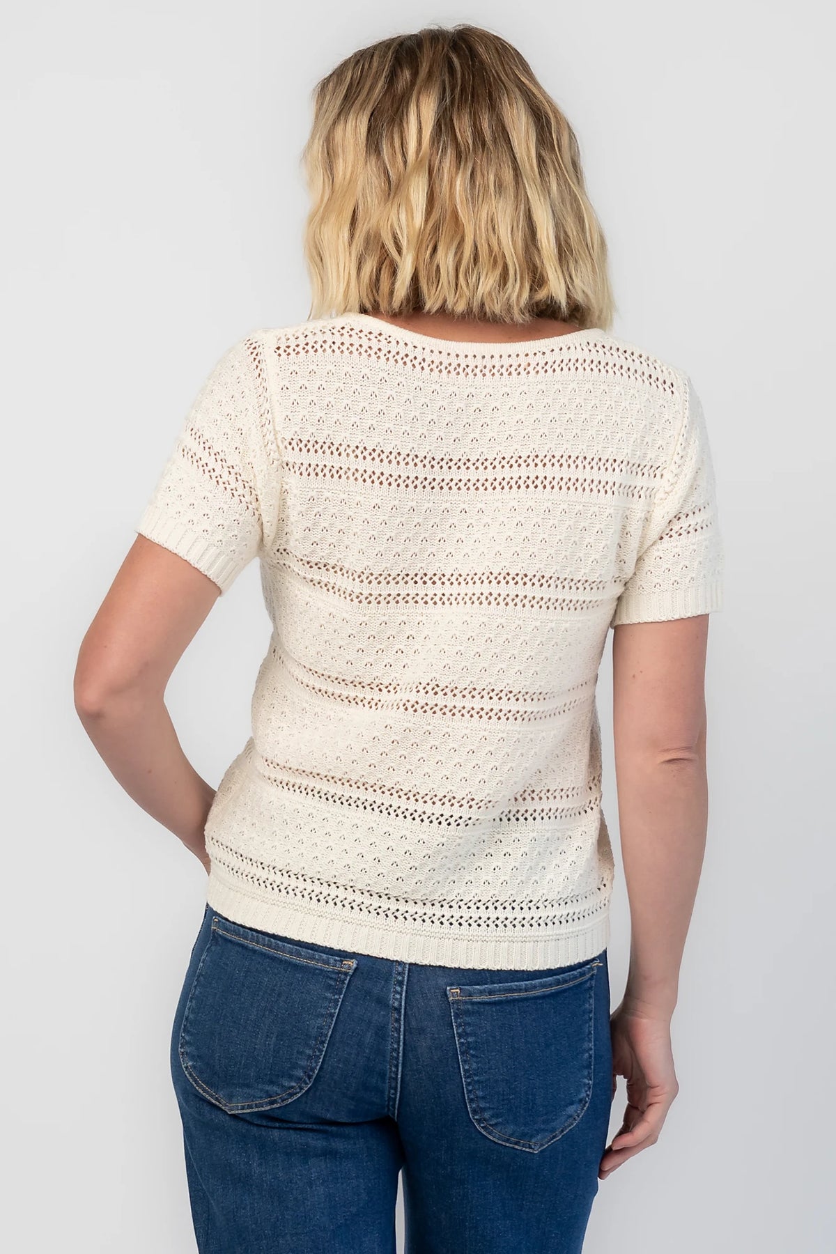 Albon Open Knit Top in Cream with V-neckline, open knit texture, and ribbed trim.