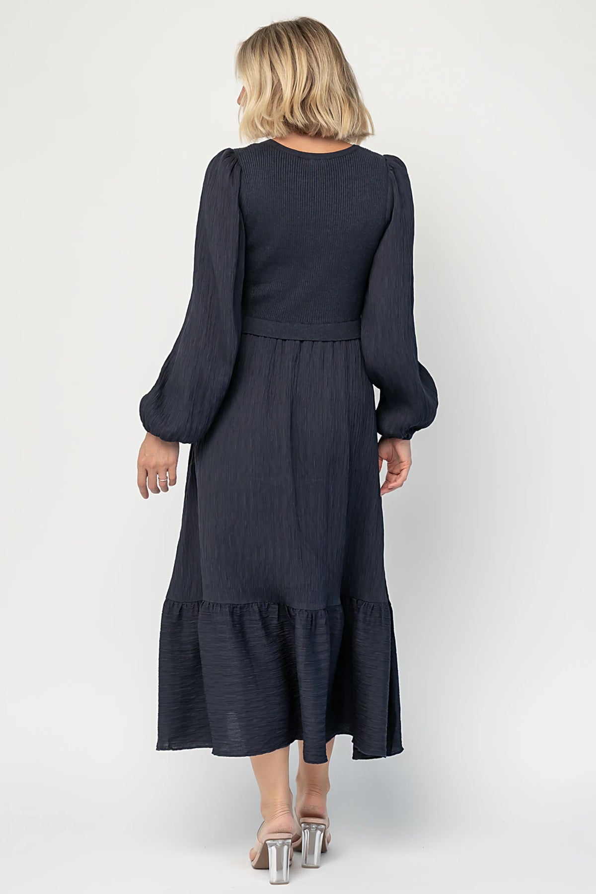 Alva Sweater Dress in Dusty Navy with ribbed knit bodice, square neckline, ruffle shoulders, long sleeves, and midi skirt.