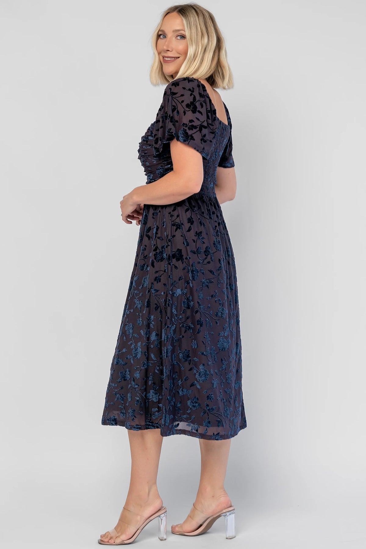 Amoret Midi Dress in Midnight Navy Floral with raised velvet florals, a sweetheart neckline, and flutter sleeves.