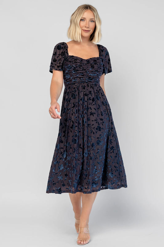 Amoret Midi Dress in Midnight Navy Floral with raised velvet florals, a sweetheart neckline, and flutter sleeves.