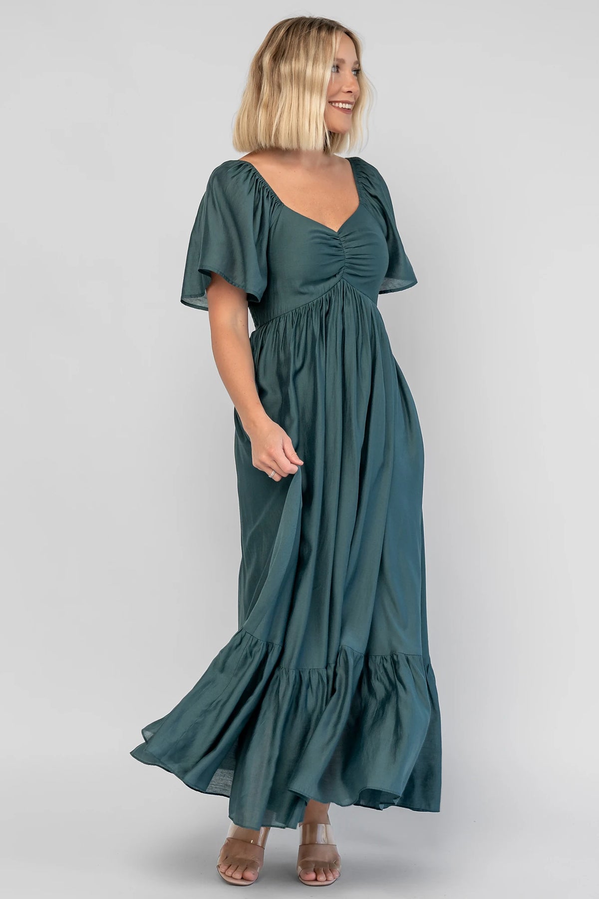 Anisa Midi Dress in Emerald with a V-neckline, cinched bust, and elastic shoulders.