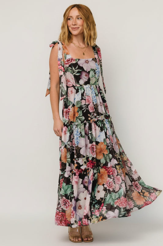 Studio front view of the Anita Maxi Dress in black multi floral showing the square neckline, smocked back, and flowing tiered chiffon skirt.