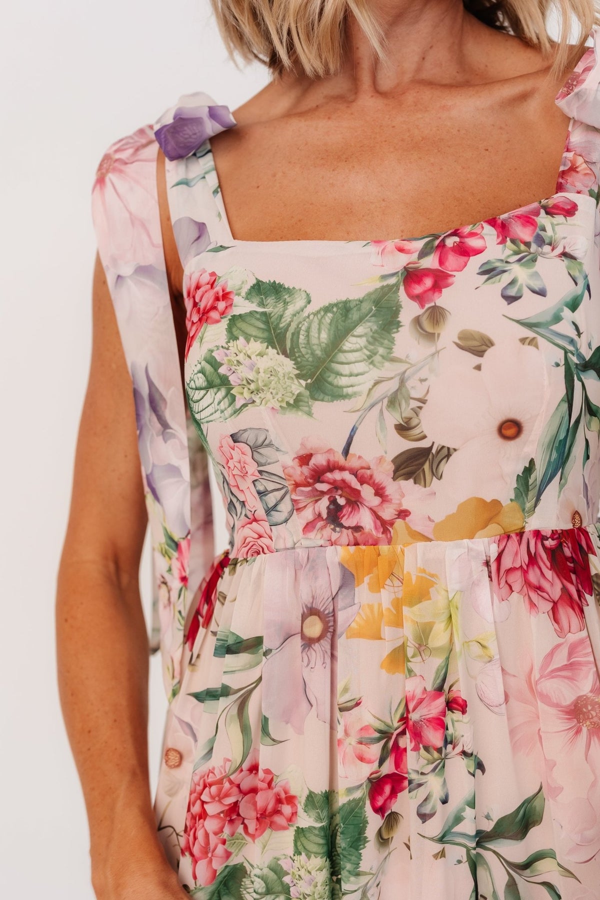 Back view highlighting the smocked back panel and adjustable straps on the blush multi floral maxi dress for a secure fit.