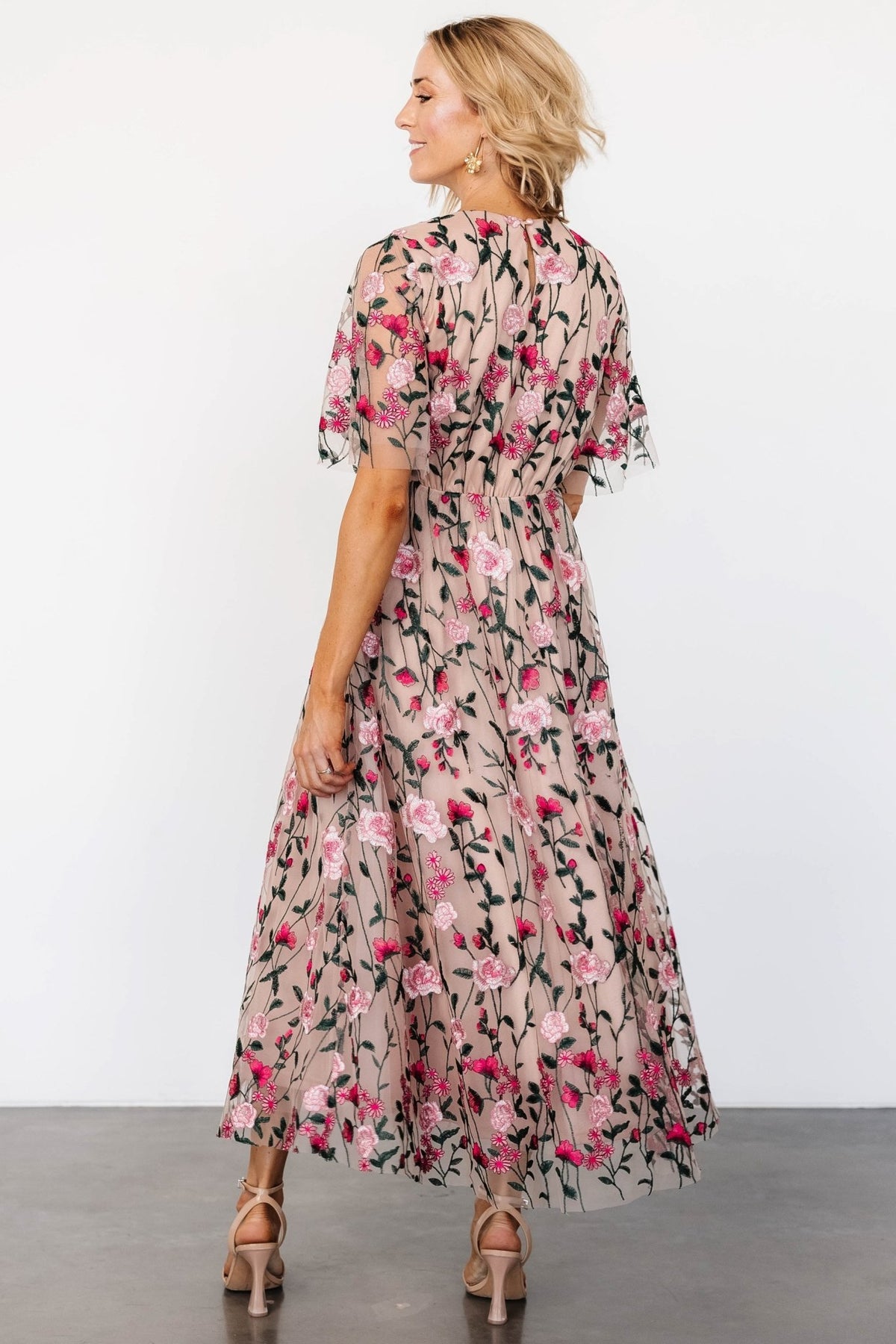 Sheer short sleeve detail with embroidered floral accents and visible contrast between lined body and sheer overlay.