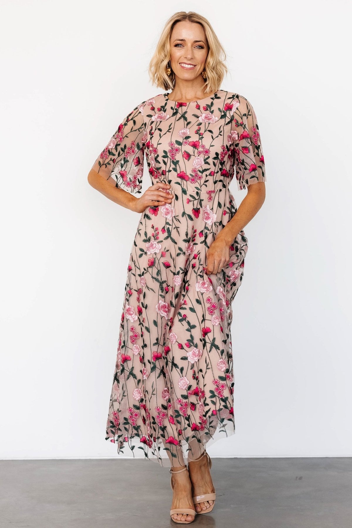 Front view of Arabella tulle maxi dress in muted blush with pink, green and off‑white embroidered floral motifs and layered tulle volume.