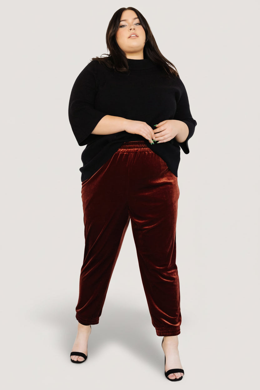 Back view of Archie cinnamon velvet joggers on model, showing elastic waistband and relaxed seat for comfortable wear.