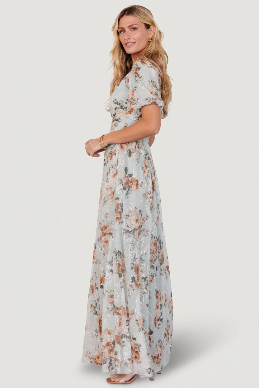 Detailed close-up of sleeve and neckline showing puff sleeve elastic, V-neck finish, and embroidered accents on a soft mesh overlay.