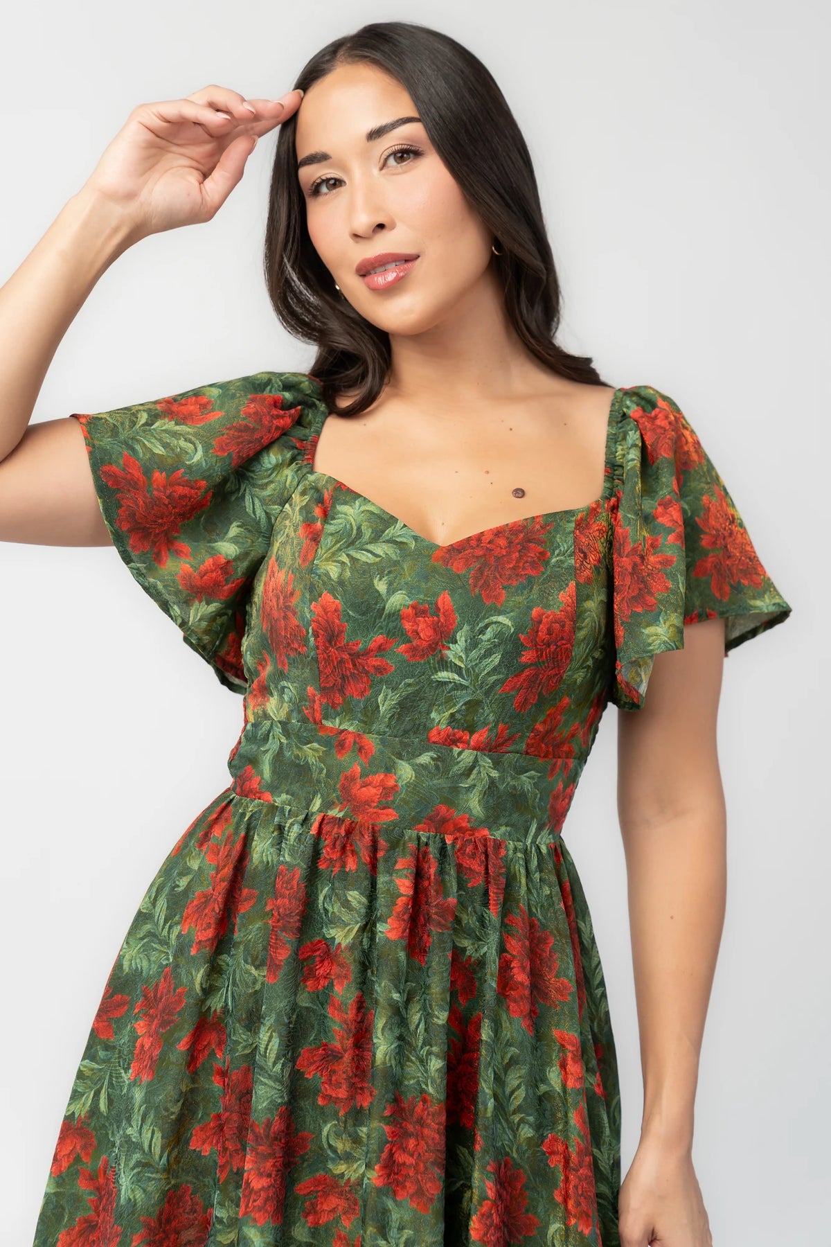 Astor Maxi Dress in Green + Red with floral print, sweetheart neckline, flutter sleeves, smocked back, and flowing skirt.