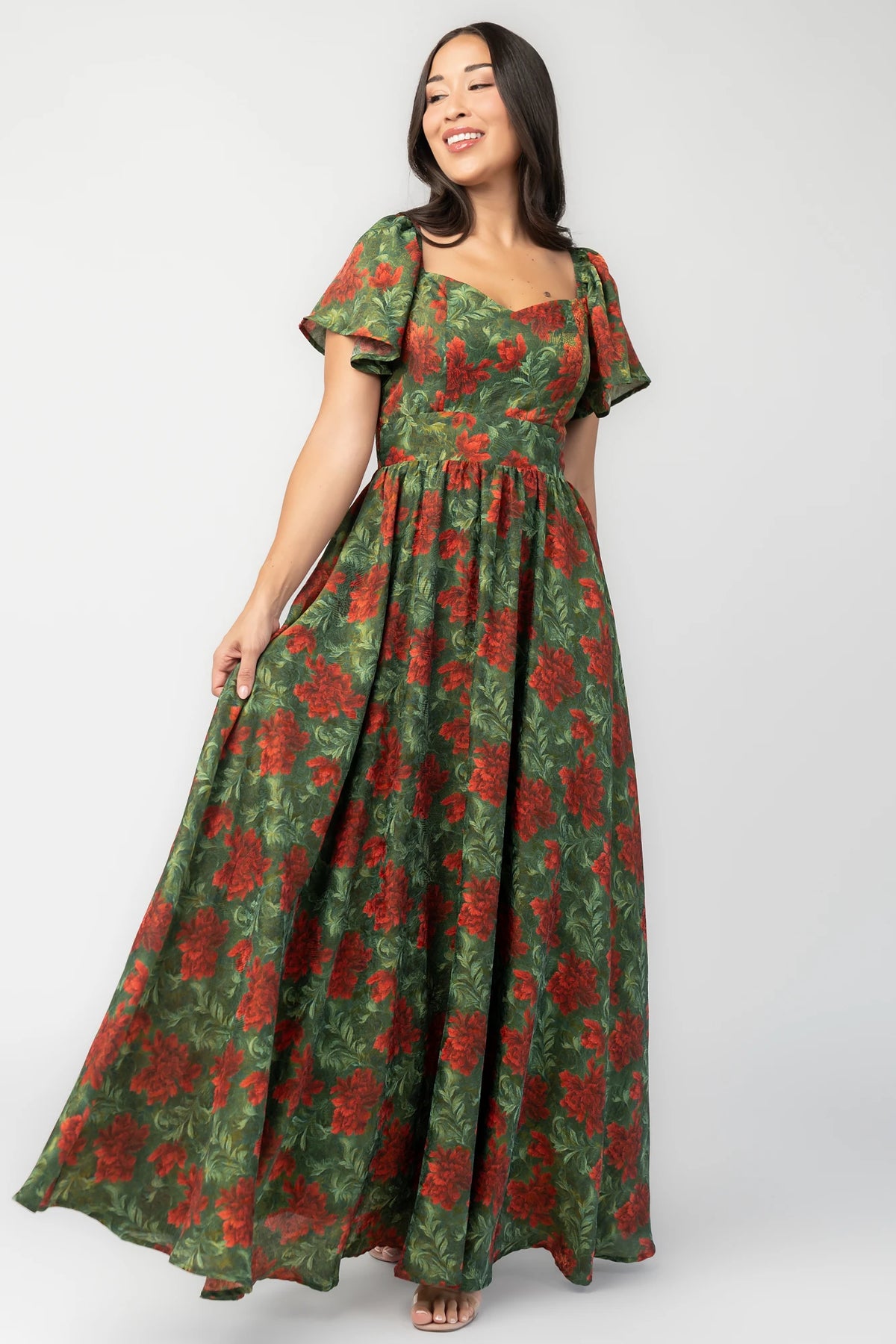 Astor Maxi Dress in Green + Red with floral print, sweetheart neckline, flutter sleeves, smocked back, and flowing skirt.
