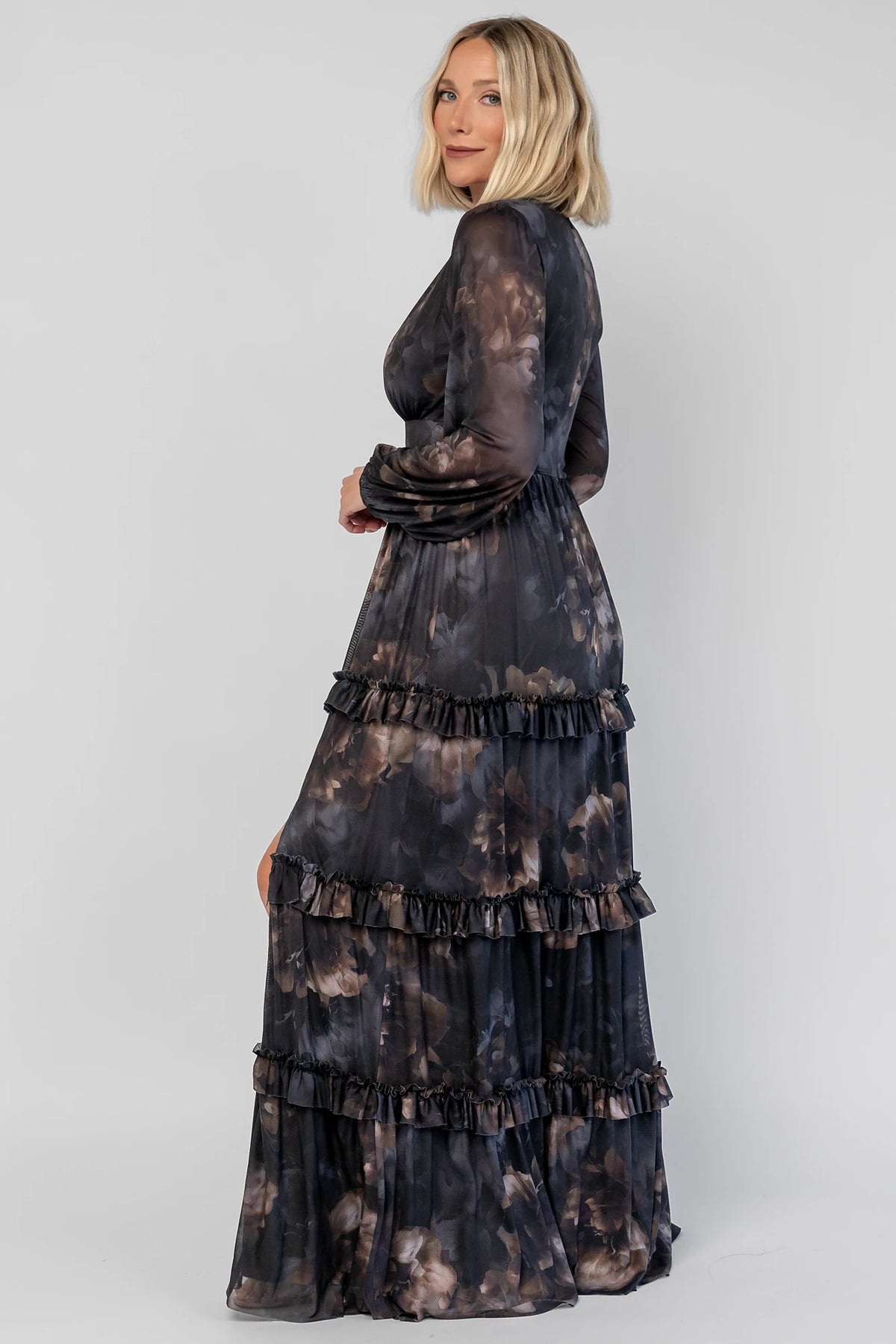 Astraea Maxi Dress in Midnight Floral with a deep V-neckline, sheer sleeves, and a tiered maxi skirt with leg slit.