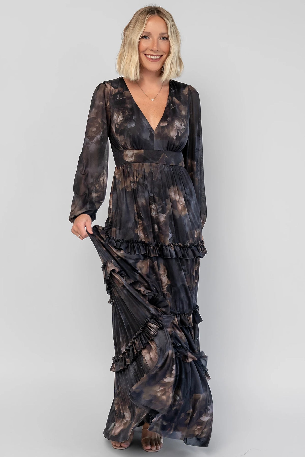 Astraea Maxi Dress in Midnight Floral with a deep V-neckline, sheer sleeves, and a tiered maxi skirt with leg slit.