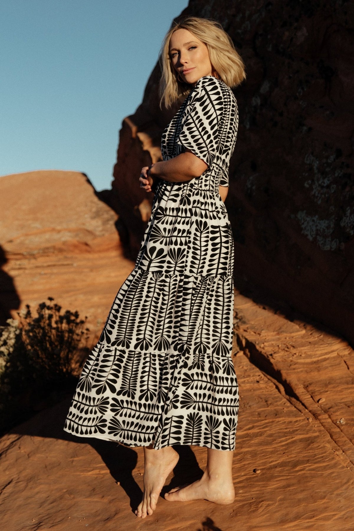 Detail of sleeve and shoulder showing loose kimono sleeve shape and V-neck seam on the Austin Kimono Dress in black print.