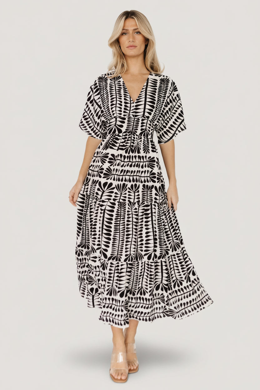 Front view of Austin Kimono Midi Dress in black and ivory print on model; V-neck, smocked back, tiered midi skirt, fully lined and flowing.