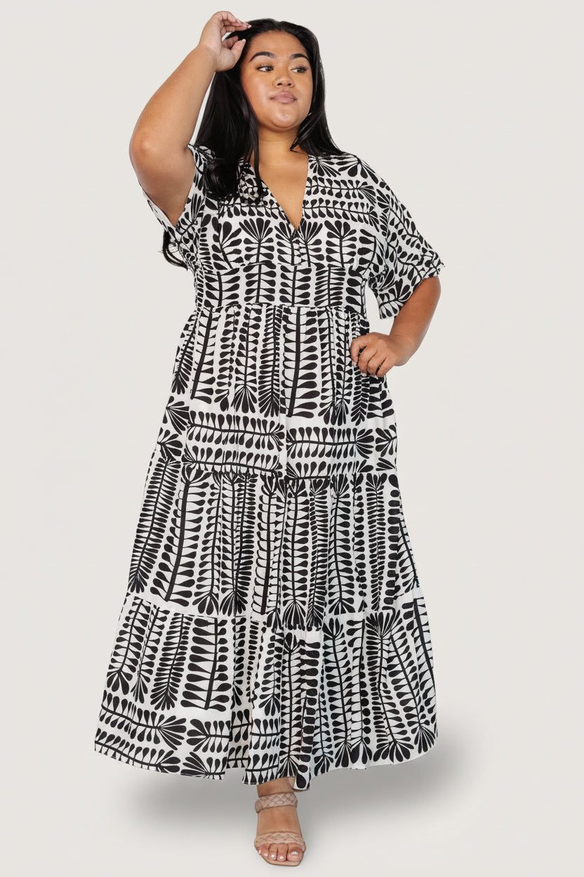 Full-length view of Austin Kimono Dress on model, displaying relaxed fit, tiered skirt, and ankle-grazing midi length in black print.