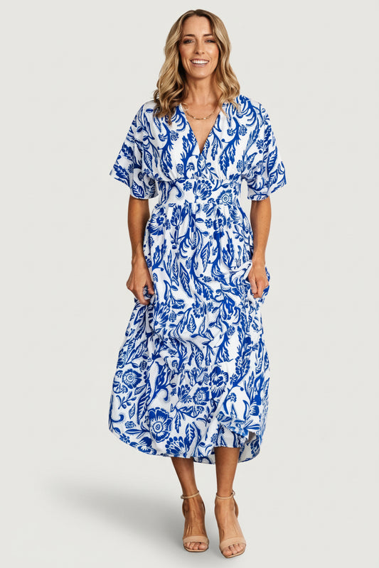 Front view of cobalt blue printed kimono midi dress on model, showing V-neck, loose kimono sleeves and tiered midi skirt with gentle drape.