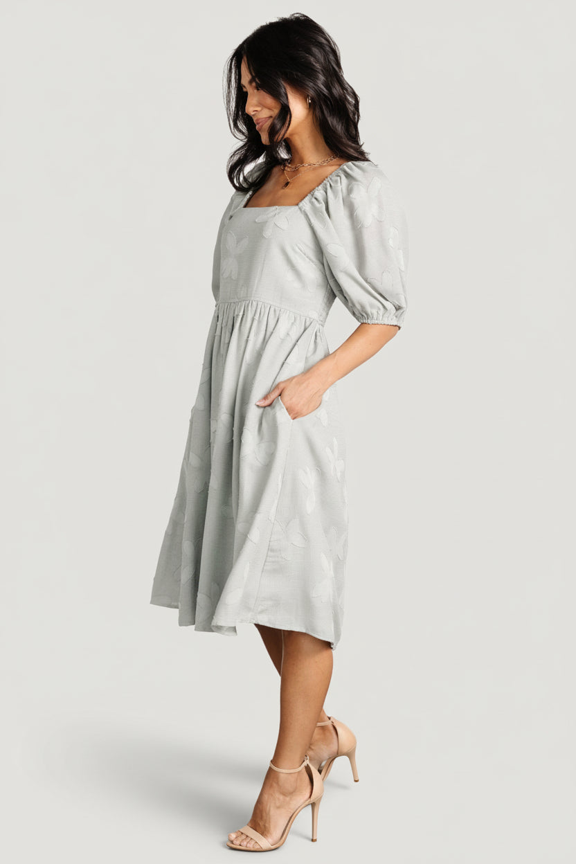 Sleeve detail showing mid-length puff shape, elastic at the shoulder and cuff, and unlined sleeve construction.