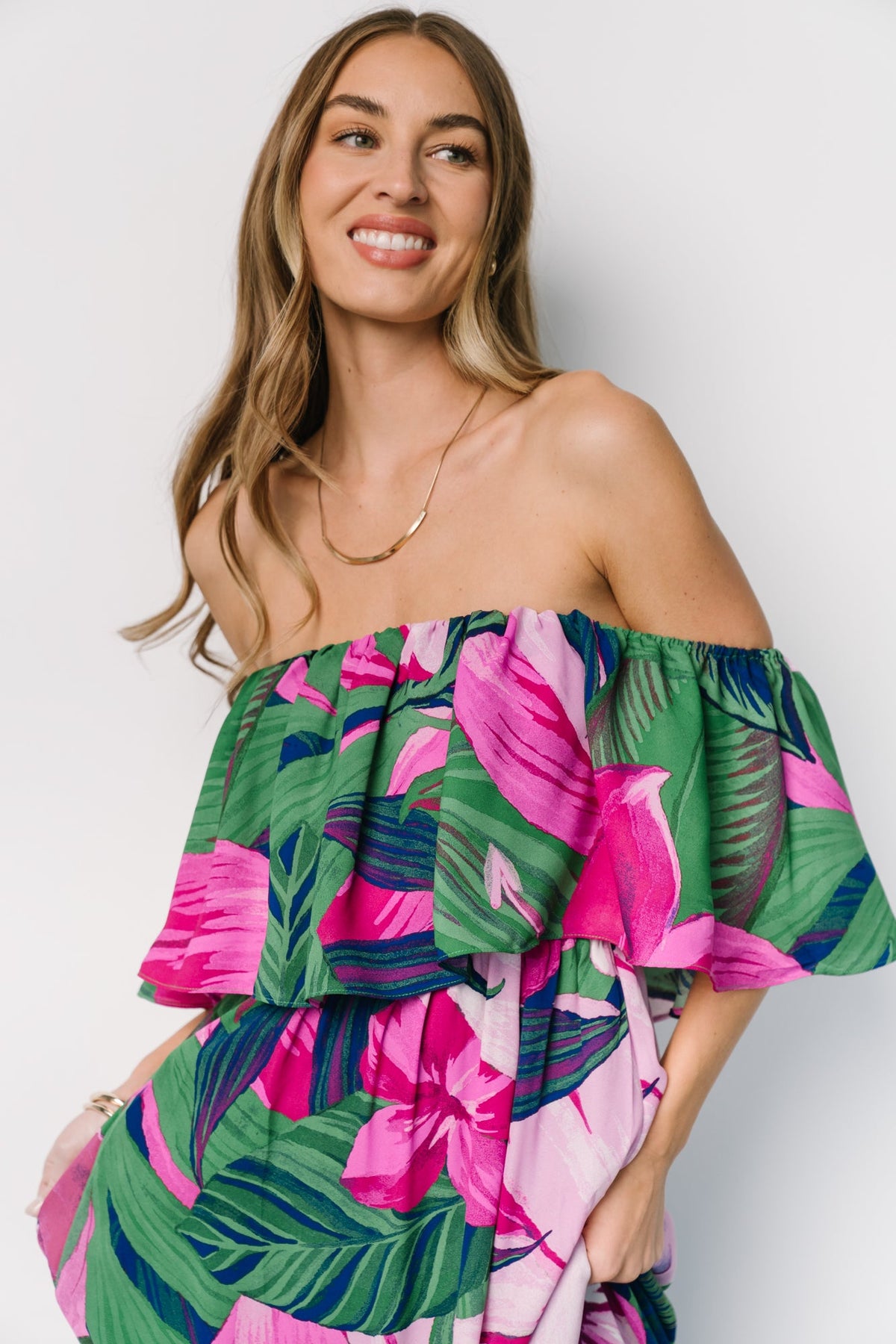 Side view of Azalea maxi dress in green and fuchsia floral, showing flowing chiffon skirt movement and elastic waist shaping on model.