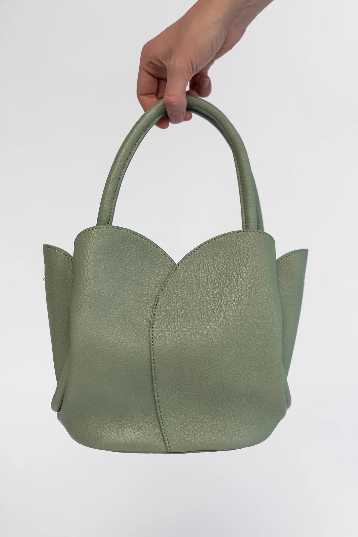 Beloved Tulip Tote Bag in Moss with a soft pebbled texture, tulip-inspired panel detailing, and rounded top handles.