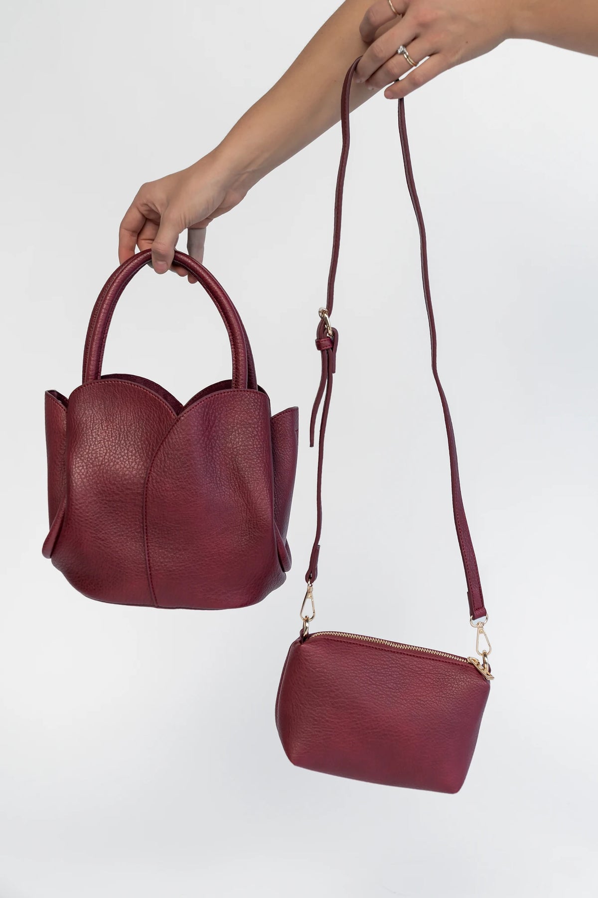 Beloved Tulip Tote Bag in Wine with a soft pebbled texture, tulip-inspired panel detailing, and rounded top handles.