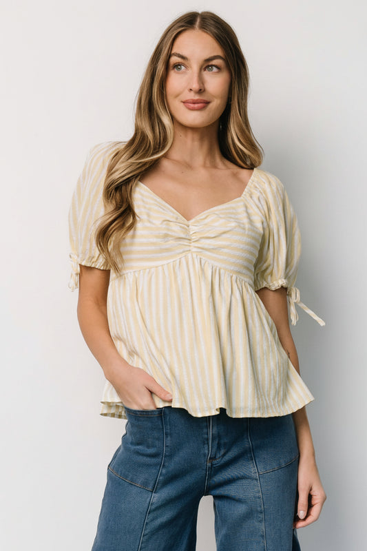 Front view of Betsy Peplum Top in pastel yellow and white stripes, showing peplum hem and gathered bust details.