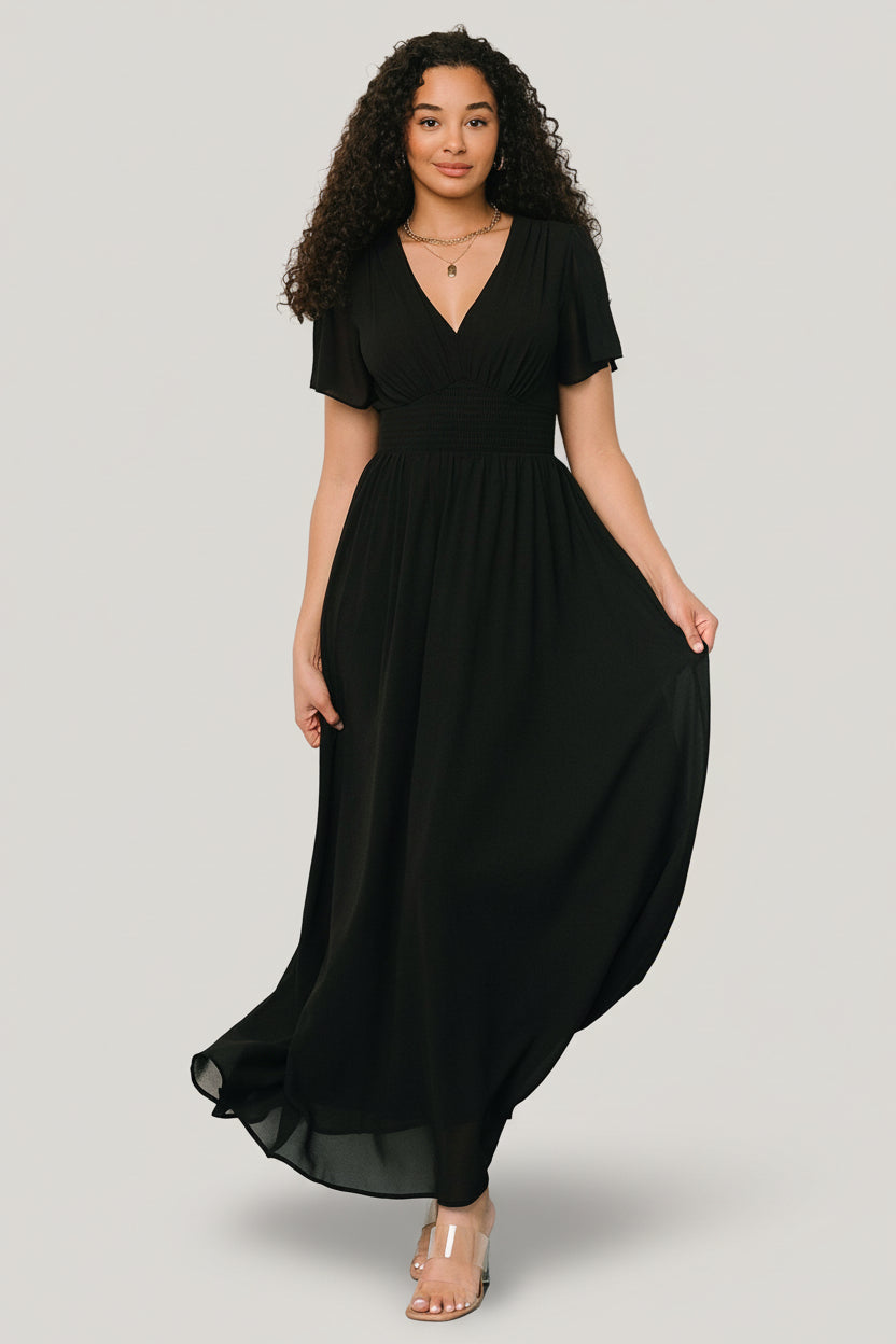 Front view of Birdie Maxi Dress in black, flowing chiffon with V-neck, smocked waist and short flutter sleeves, lined through body.