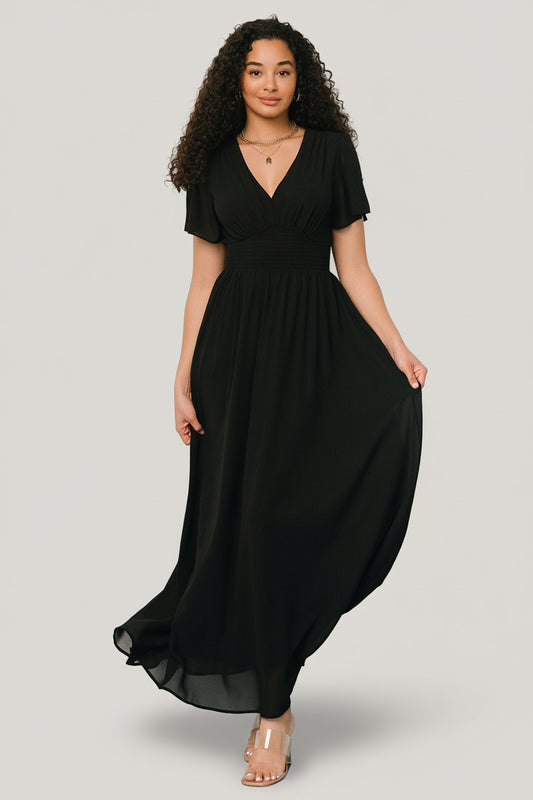 Front view of Birdie Maxi Dress in black, flowing chiffon with V-neck, smocked waist and short flutter sleeves, lined through body.