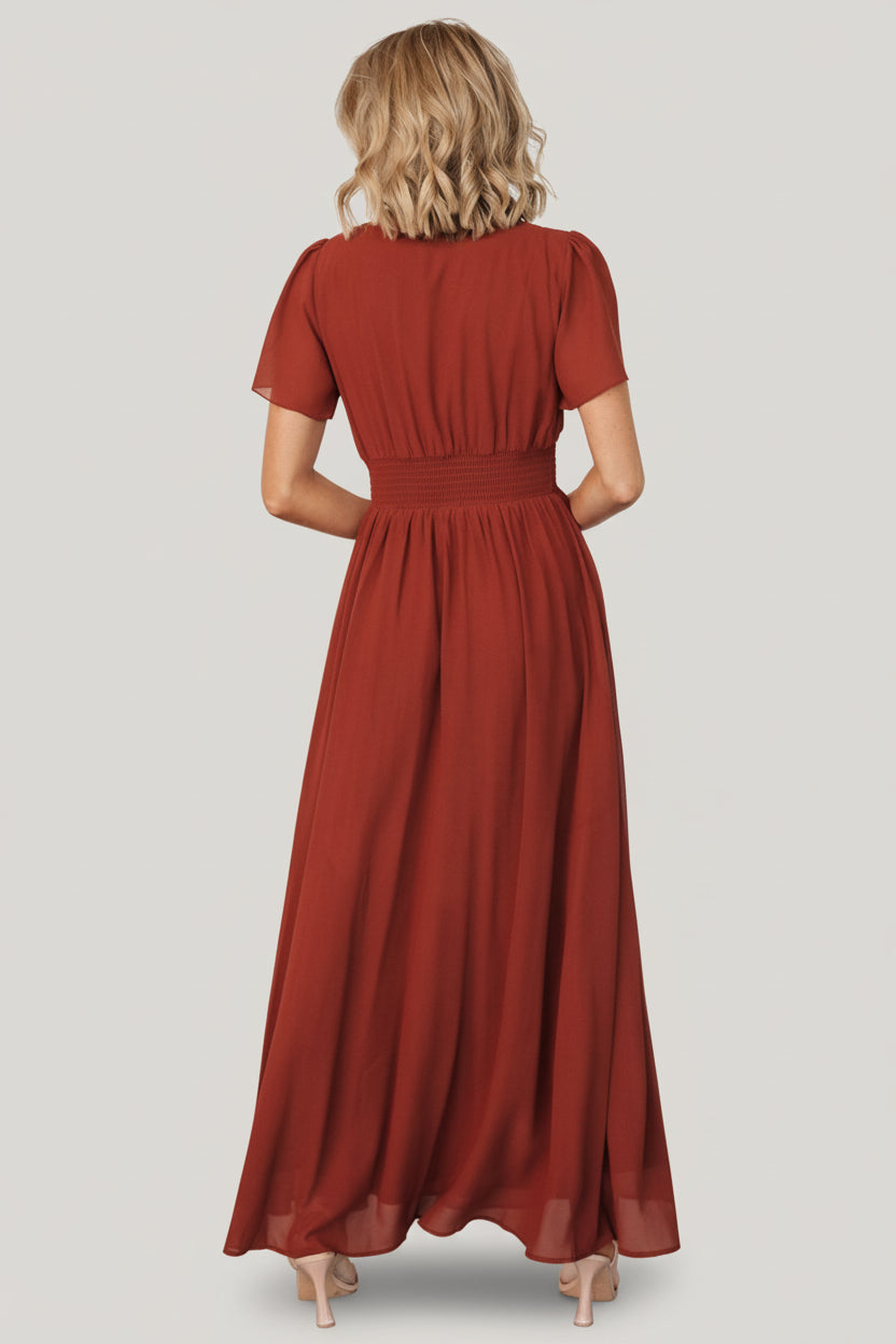 Close-up of the dress bodice in cinnamon showing the V-neck detail, smocked waist band, and delicate flutter sleeve edge.