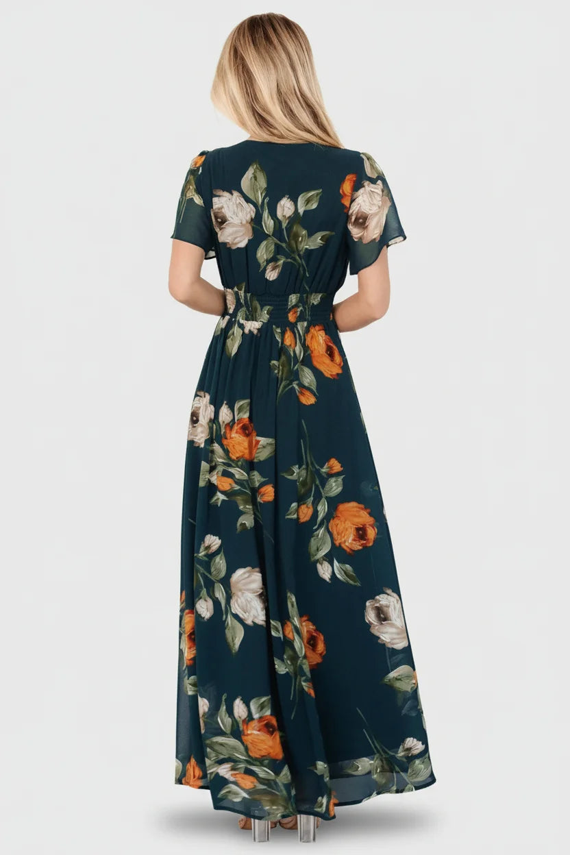 Model seated in deep topaz floral maxi dress demonstrating movement of lightweight chiffon and lined skirt.