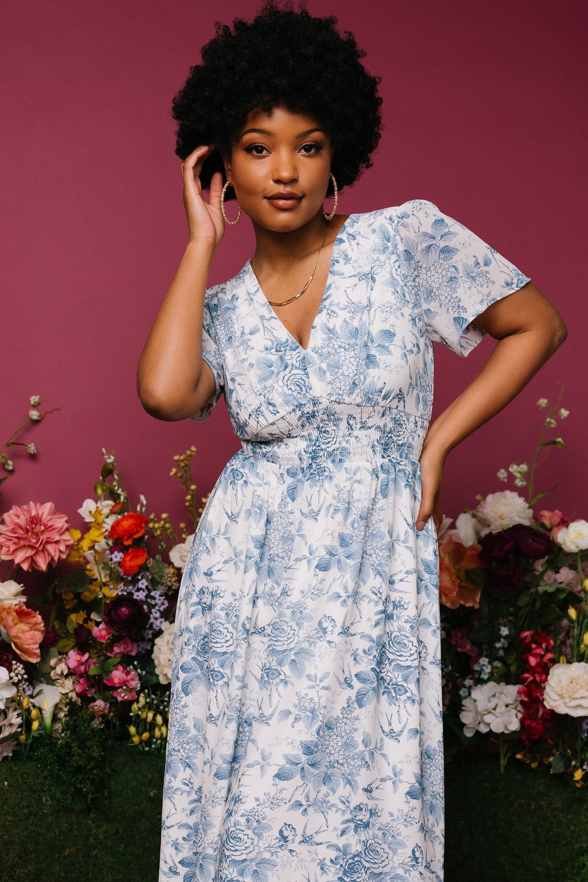 Detail of short flutter sleeve and V-neckline in off-white chiffon with delicate blue floral pattern.