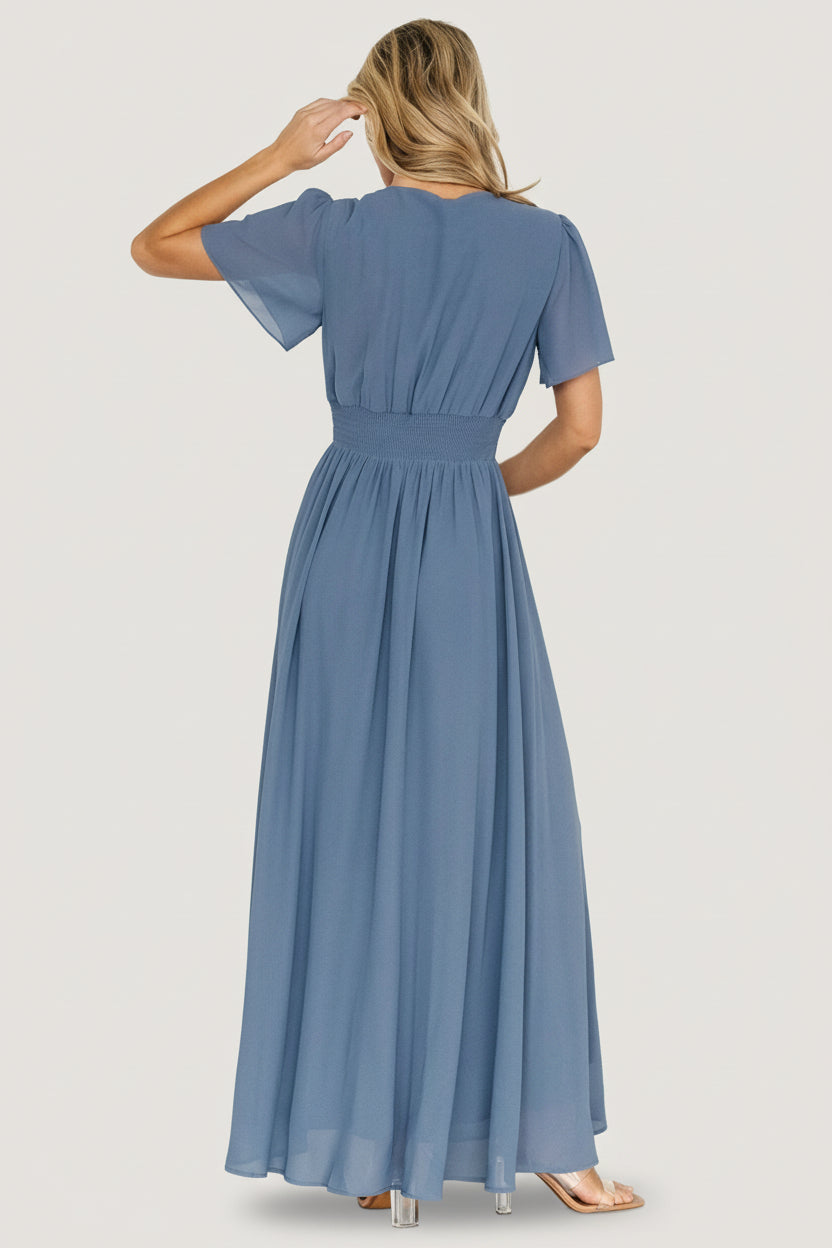 Close-up of the smocked waist and V-neckline on the Birdie Maxi Dress in Whisper Blue showing fabric texture and seam detail.