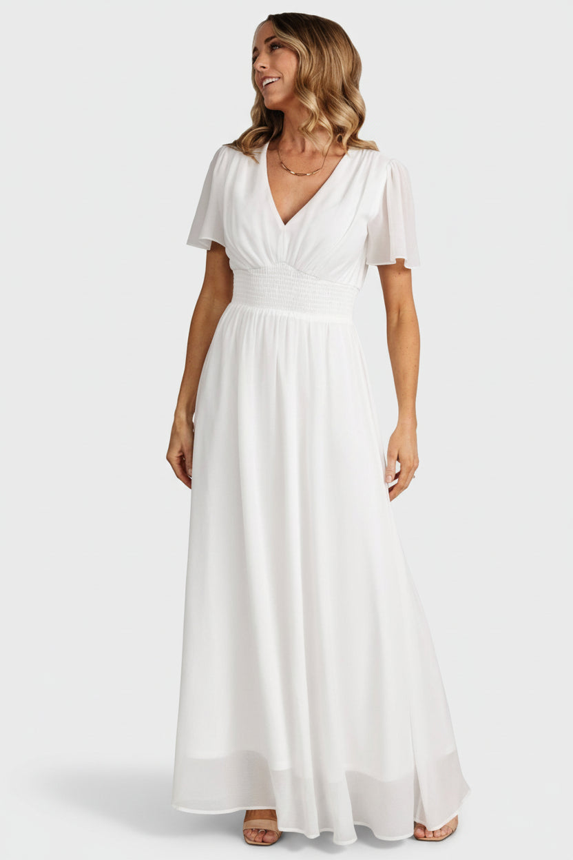 Styled flat-lay and hang view of the Birdie Maxi Dress in white, displaying flutter sleeves, V-neckline and smocked waist proportions.
