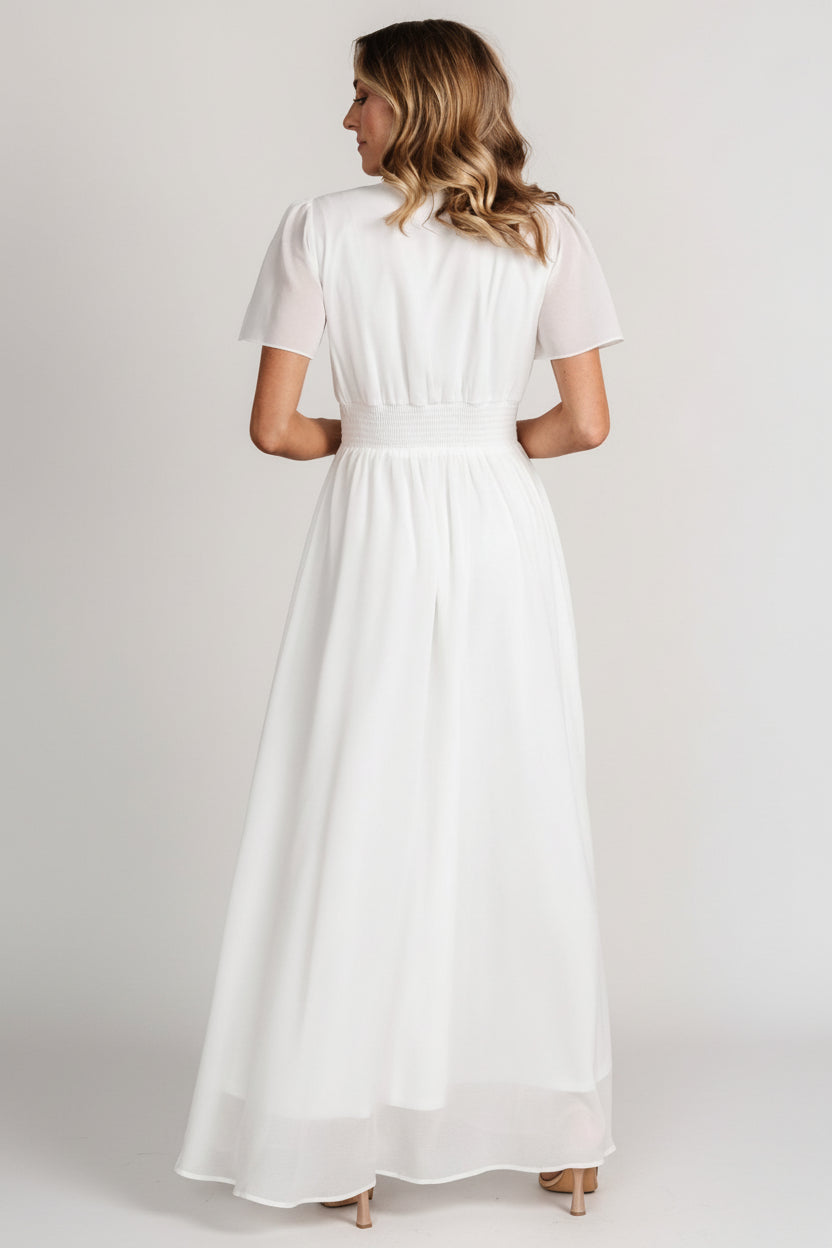Full-length shot of model walking in the Birdie dress, illustrating skirt movement, flutter sleeves and ankle-grazing maxi length.