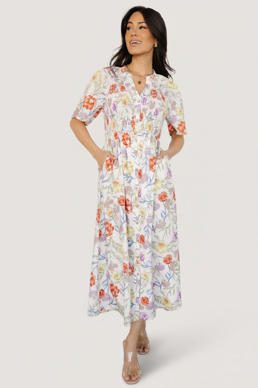 Front view of ivory floral rayon midi dress with ruffled notched neckline, smocked front bodice, elastic waist, and attached lining, on white background.