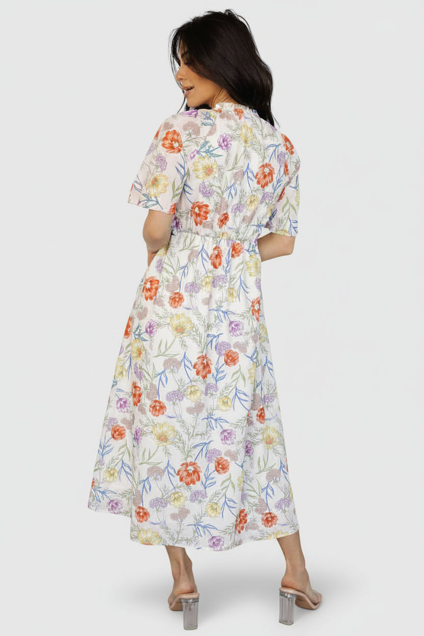 Back view of ivory floral rayon midi dress showing midi length skirt and attached polyester lining for added coverage and structure.