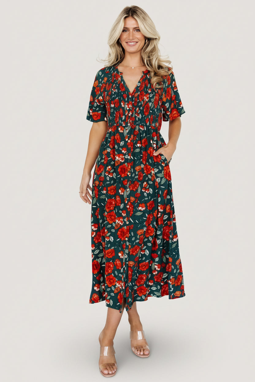 Model walking in Polagram Botega Midi Dress jade multi floral, showing skirt movement, side-seam pocket placement, and button-front detail.