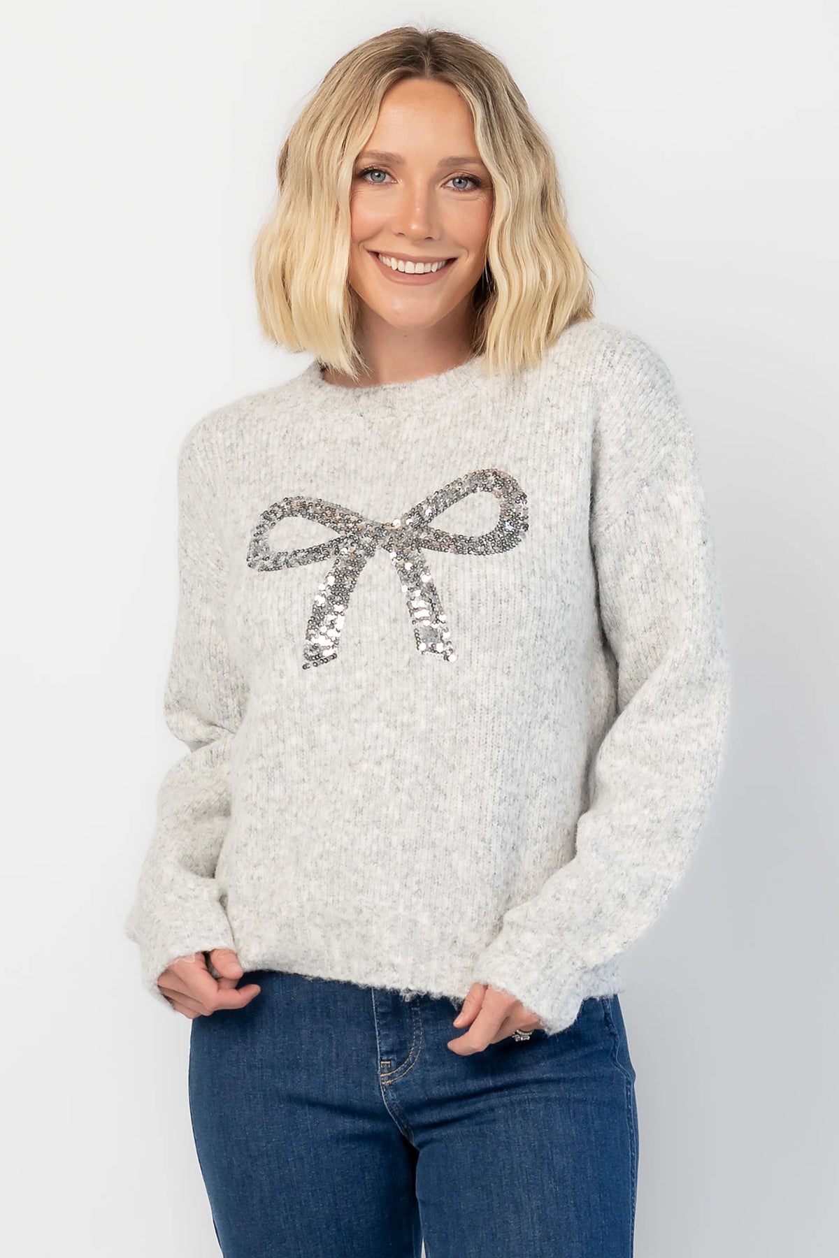 Bow Sweater in Gray with a sparkling sequin bow at the front, a crew neckline, and a heathered knit finish.