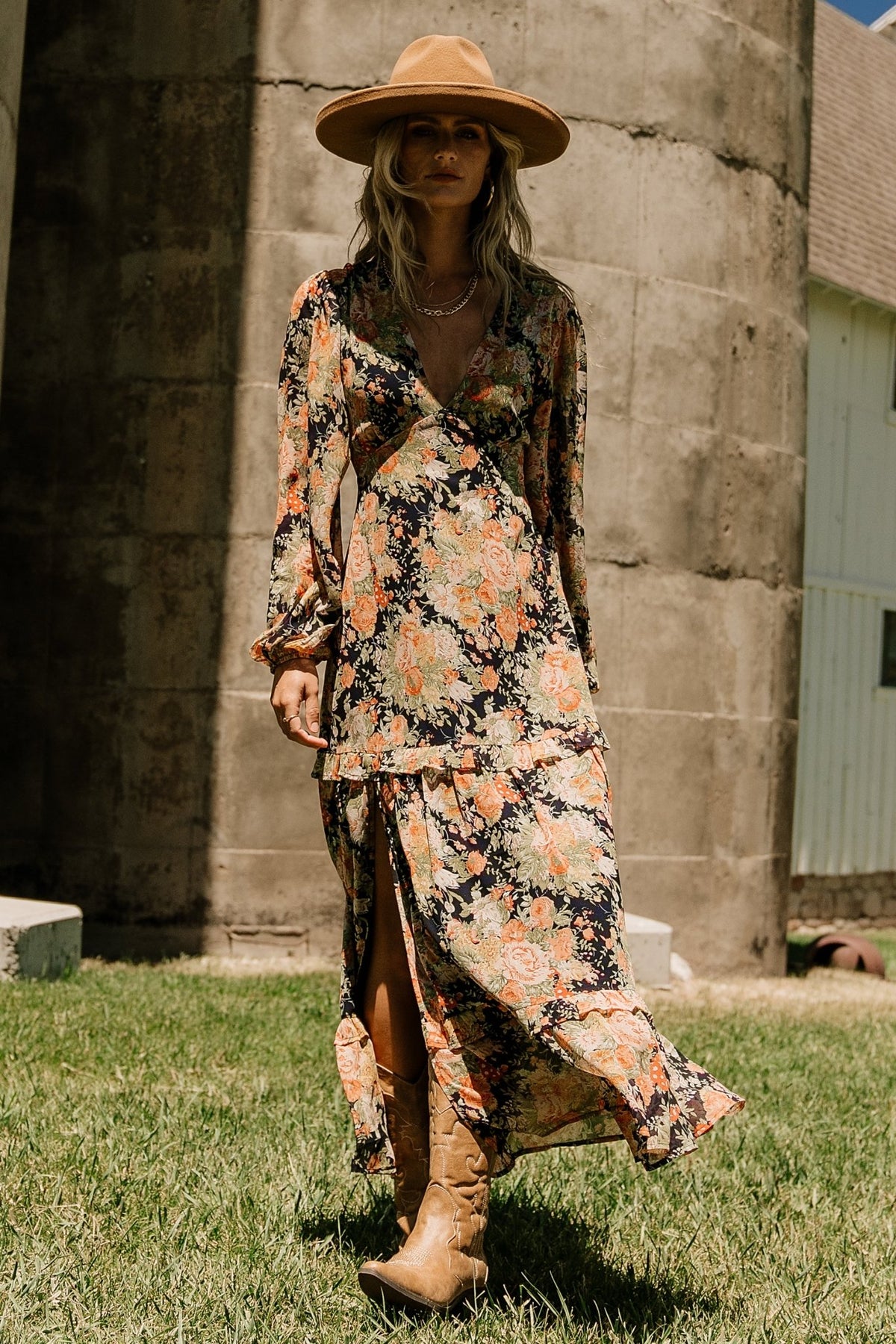 Back view of navy floral chiffon maxi dress highlighting elastic back waist, lined body and long sleeve silhouette.