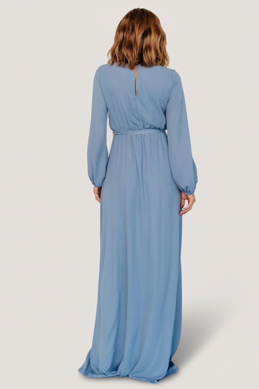 Fabric drape and skirt movement of the Breanne dress in slate blue, illustrating the flowing faux-wrap silhouette and soft polyester hand.