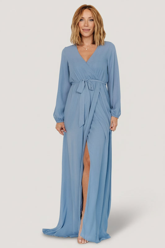 Front view of Breanne Faux Wrap Maxi Dress in slate blue showing crossover V-neck, long sleeves, elastic cuffs and flowing faux-wrap skirt, full length.