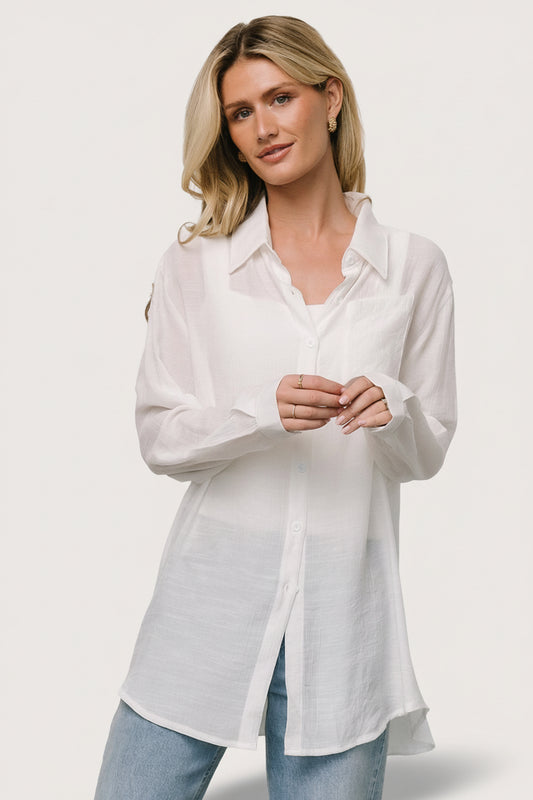 Front view of Breck Button Up Top in off white; lightweight linen-like fabric, left chest pocket, and button cuffs.