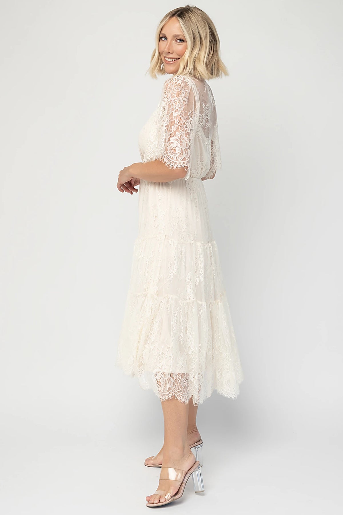 Brittany Lace Midi Dress in Vintage Cream with deep V-neck, sheer lace sleeves, elastic waist, and tiered skirt.