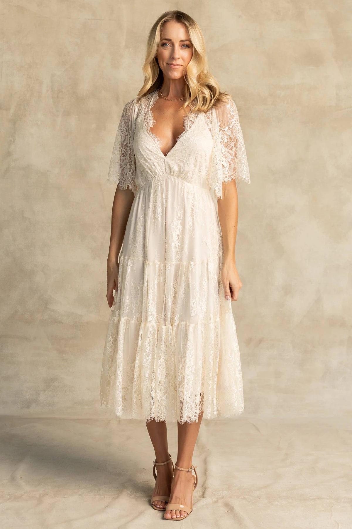 Brittany Lace Midi Dress in Vintage Cream with deep V-neck, sheer lace sleeves, elastic waist, and tiered skirt.