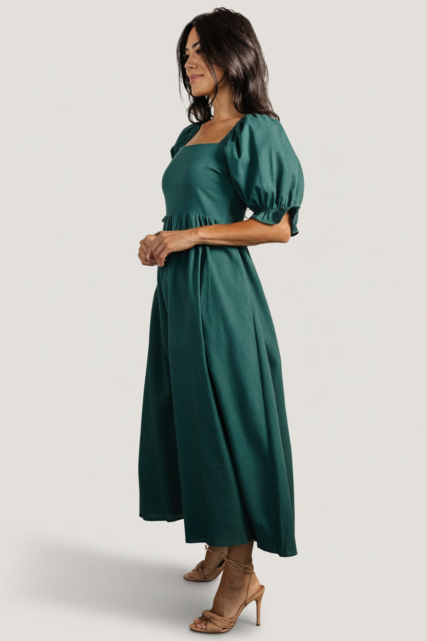 Side view of Evergreen midi dress showcasing functional side pocket, smooth skirt drape and mid-thigh lining beneath linen-blend outer fabric.